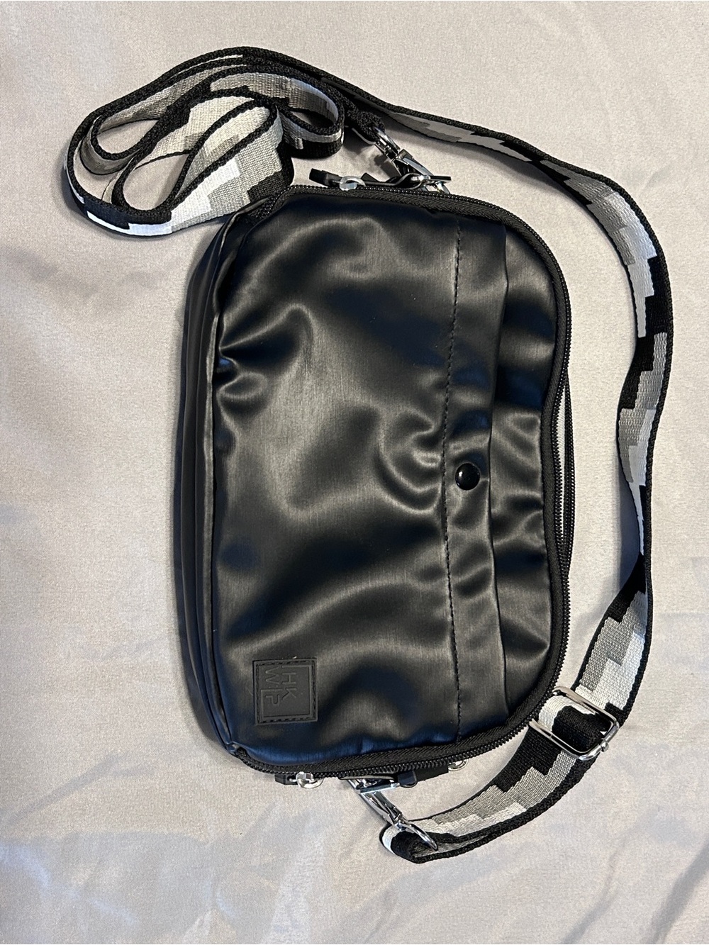 Sleek Black Crossbody Bag with Patterned Strap